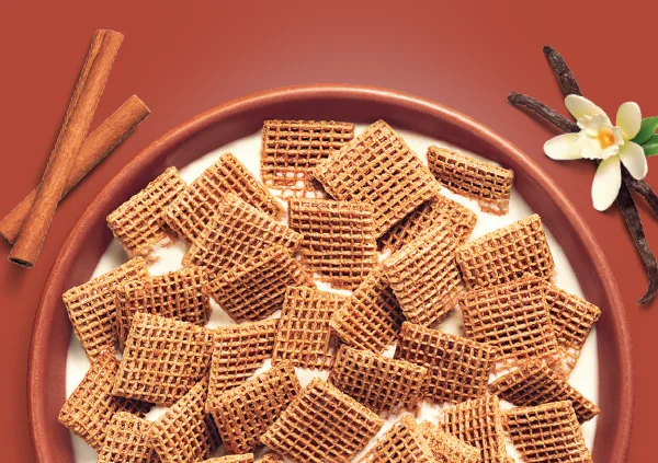 Shreddies Cinnamon Vanilla in a bowl surrounded by Cinnamon and Vanilla